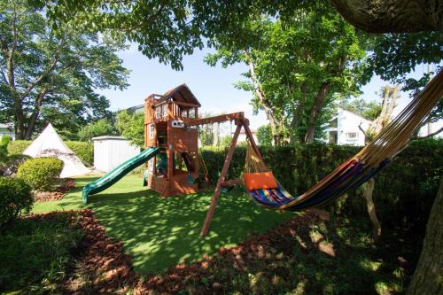 a playground with a swing set and tents at KandoStay 伊豆高原パークガーデン in Ito