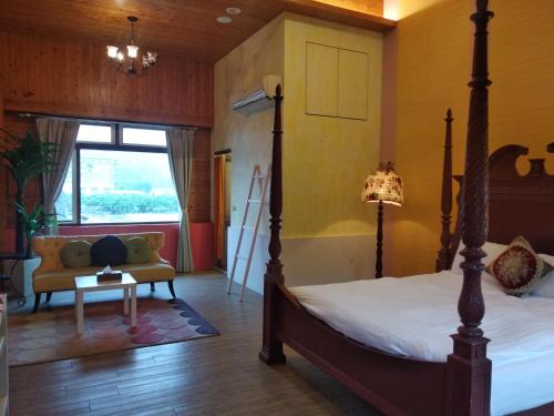a bedroom with a bed and a couch and a window at DeerStar HomeStay B&B in Dongshan
