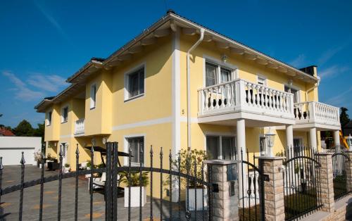 a yellow house with a balcony on it at Villa Katharina in Rust