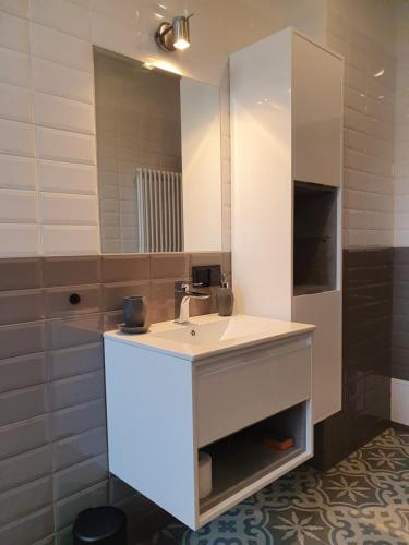 uma casa de banho com um lavatório e um espelho em B&B MILES APARTMENT em Katowice