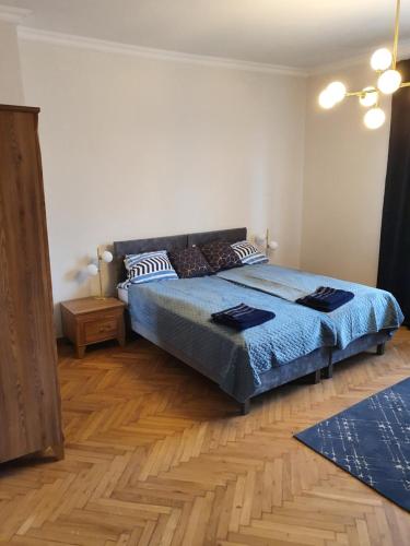 1 dormitorio con 1 cama y suelo de madera en B&B MILES APARTMENT, en Katowice