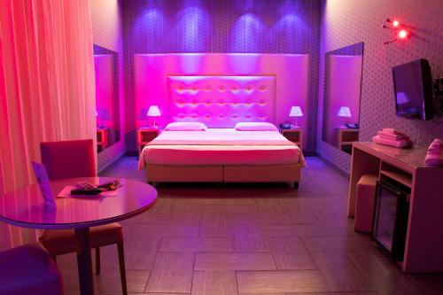 a purple bedroom with a bed and a table at Hotel Masaniello Luxury in Casoria