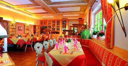 un restaurante con mesas y sillas con arcos rosados en Hotel Mair Am Bach en Bressanone