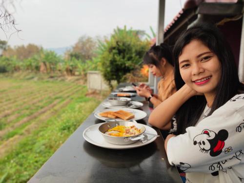 two women sitting at a table with plates of food at Bua Patumma Resort in Mae Sai