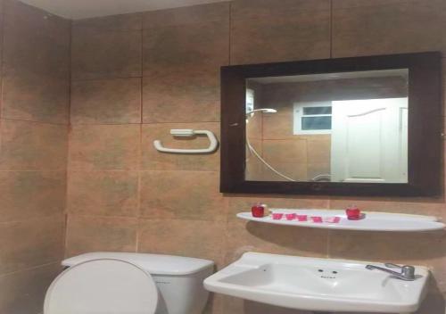 a bathroom with a toilet and a sink and a mirror at Golden Bee PhiPhi in Phi Phi Don