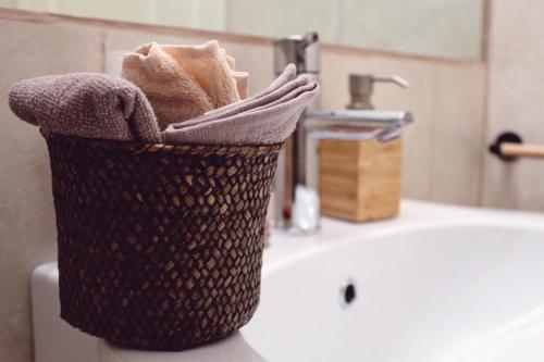 a basket of towels sitting on top of a bathroom sink at ApartHotel Le Sirene - FRIDA in Tivoli