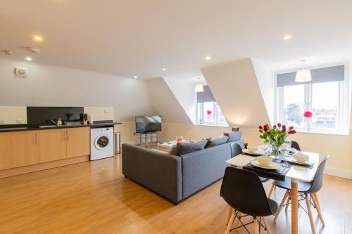 a living room with a couch and a table at 2 Bedroom Penthouse, Clockhouse, Hoddessdon in Hoddesdon