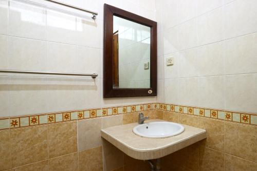 a bathroom with a sink and a mirror at Gemini Star Hotel in Kuta