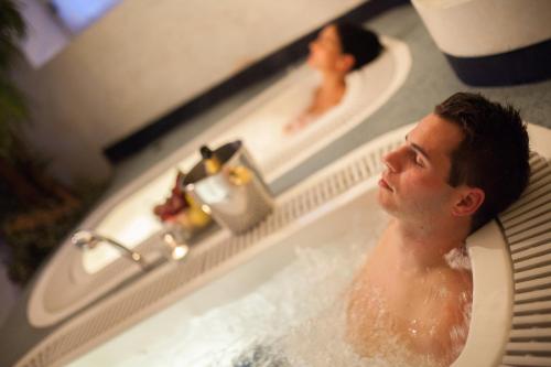Un uomo che fa il bagno in una vasca da bagno con una donna di Camping Olympia a Dobbiaco