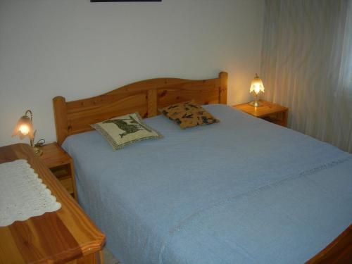 1 dormitorio con 1 cama azul y 2 mesitas de noche en Talstrasse 24 - Raimann, en Davos