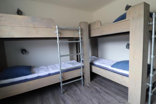 two bunk beds in a dorm room with twothirds of themsenalsenalsenalangering at Sier aan Zee in Hollum