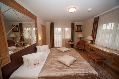 a bedroom with a bed and a desk and a mirror at Villa Katharina in Rust