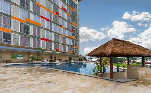 ein Hotel mit einem Pool und einem Gebäude in der Unterkunft Ascent Premiere Hotel and Convention in Malang