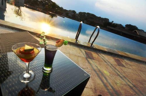 a table with two glasses on top of a balcony at Ascent Premiere Hotel and Convention in Malang