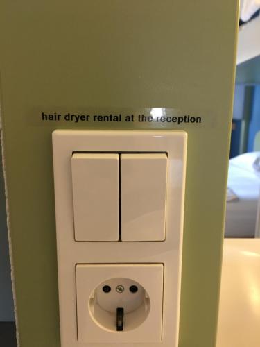 a urinal in a bathroom with the words hair drier rental at the reception at ibis budget Muenchen Putzbrunn in Putzbrunn