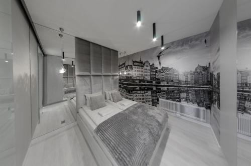ein Schlafzimmer mit einem Bett in der Mitte eines Zimmers in der Unterkunft Elite Apartments Granaria Luxury in Danzig