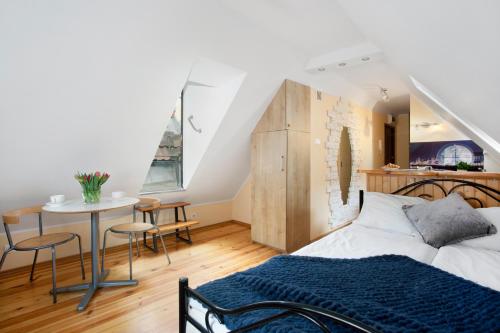 a bedroom with a bed and a table with chairs at Elite Apartments Rooftop with a View of the Old Town in Gdańsk