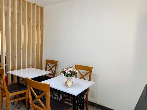 a table and chairs with a vase of flowers on it at A Alma Portuguesa in Fátima