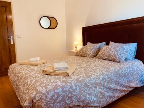 a bedroom with a large bed with towels on it at A Alma Portuguesa in Fátima