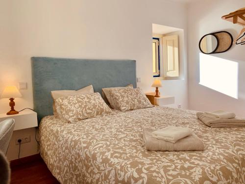 a bedroom with a large bed with a blue headboard at A Alma Portuguesa in Fátima