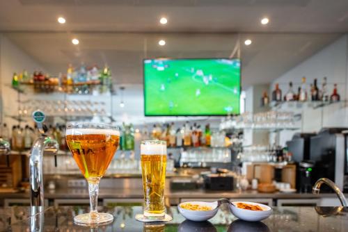 two glasses of beer sitting on top of a bar at Best Western Plus Paris Velizy in Vélizy-Villacoublay