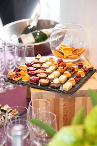 a table with a tray of pastries and wine glasses at Best Western Plus Paris Velizy in Vélizy-Villacoublay