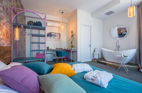 a bathroom with a bed with colorful pillows and a tub at Redrum Tbilisi Boutique Hotel in Tbilisi City