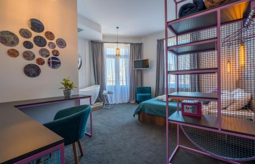 a hotel room with a bedroom with a bed and a desk at Redrum Tbilisi Boutique Hotel in Tbilisi City