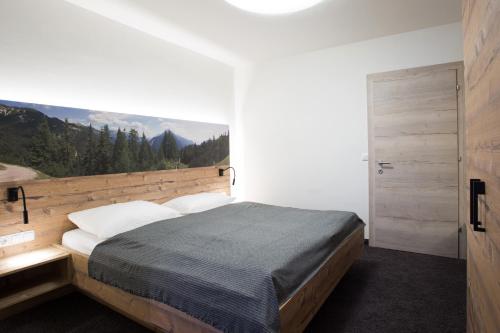 a bedroom with a bed with a large window at Aparthotel Tyrol in Lermoos
