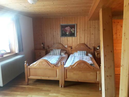 - 2 lits dans une chambre dotée de murs en bois dans l'établissement Ferienhaus Schweissing, à Fröhnd