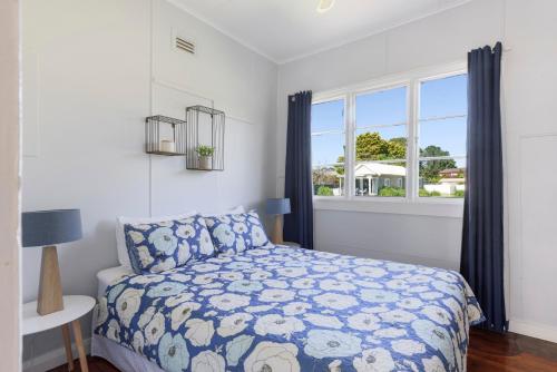 un dormitorio con una cama y una ventana en Calm Waters Waterfront Cottages, en Sussex Inlet