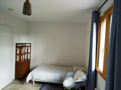 - une chambre avec un lit et une chaise avec un animal farci dans l'établissement Maison Cheptainville AVEC TERRASSE SUR VERDURE, à Cheptainville