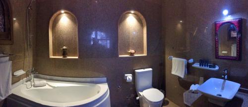 a bathroom with a tub and a toilet and a sink at Djorff Palace in Luxor