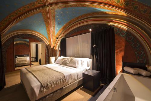 a bedroom with a large bed with a painting on the ceiling at Zenit Convento San Martin in San Sebastián