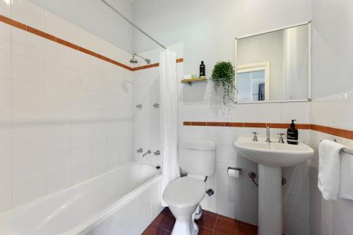 uma casa de banho com um WC, um lavatório e uma banheira em Calm Waters Waterfront Cottages em Sussex inlet