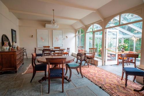 a dining room with tables and chairs and windows at Victorian House in Grasmere