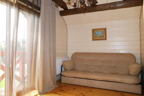 a couch sitting in a room with a window at Apple House in Mykulychyn