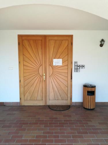 a large wooden door in a room with a trash can at Figula Vendégház in Balatonfüred