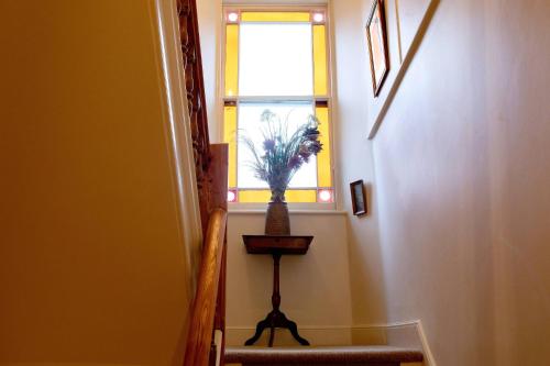 a stairway with a window and a plant in a vase at Victorian House in Grasmere