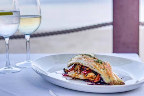 a plate of food on a table with wine glasses at Hoposa Bahia in Port de Pollensa