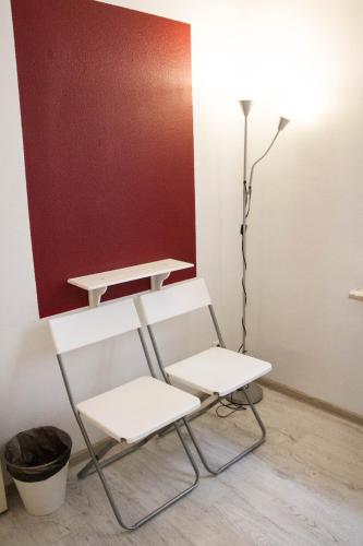 a white chair and a lamp in a room at Amber Private Rooms in Rīga