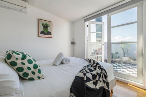 1 dormitorio con cama y ventana grande en StayCentral - Fitzroy Converted Warehouse Penthouse, en Melbourne