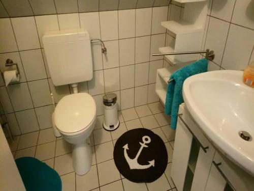 a small bathroom with a toilet and a sink at La Casa Ferienwohnung Seeadler in Steinberg