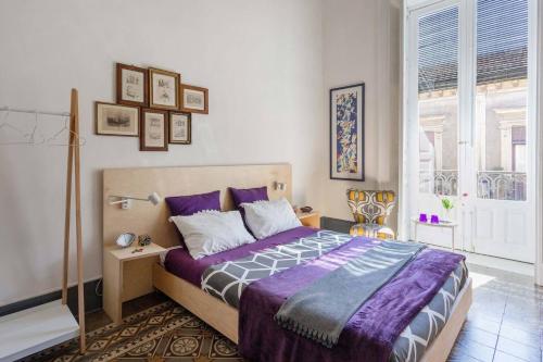 una camera da letto con un grande letto con lenzuola viola di Trìcora Sicilian B&B a Catania
