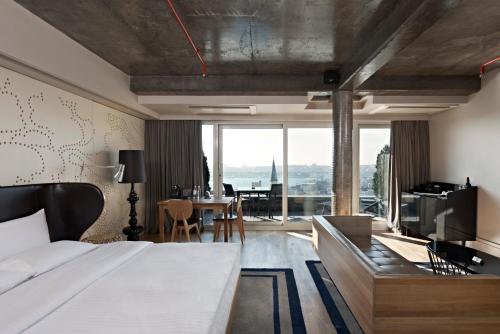 a bedroom with a bed and a living room with a table at Witt Istanbul Suites in Istanbul
