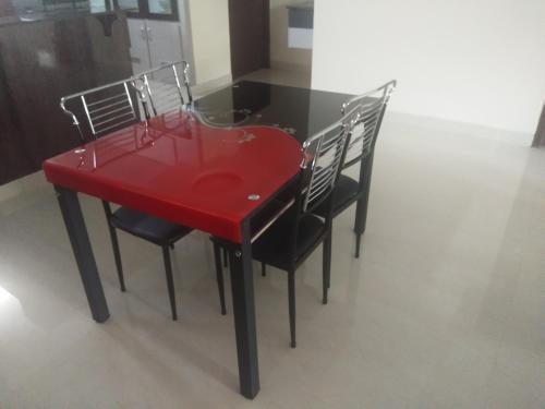 una mesa roja con cuatro sillas alrededor en Feel like home -Guest House near Tenneti park, en Visakhapatnam