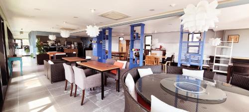 ein Restaurant mit Tischen und Stühlen und einem Speisesaal in der Unterkunft Dombe Resort in Seogwipo