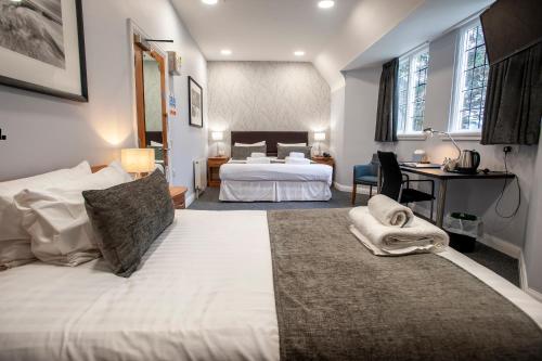 a hotel room with two beds and a desk in it at The Management Centre in Bangor
