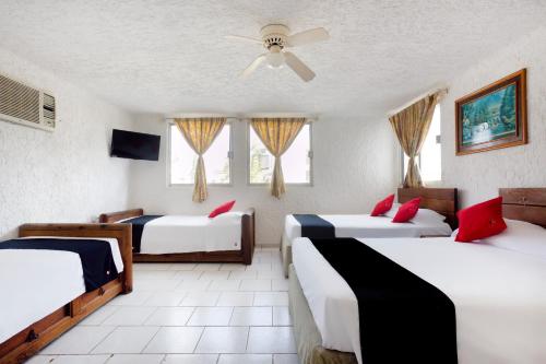 a bedroom with two beds and a ceiling fan at Capital O Farallon Inn, Cancún in Cancún