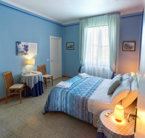 1 dormitorio con paredes azules, 1 cama y 1 mesa en B&B Planizie en Corridonia